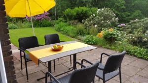 un tavolo e sedie con ombrellone in giardino di Ferienwohnung In Zendscheid Mit Offenem Kamin a Zendscheid