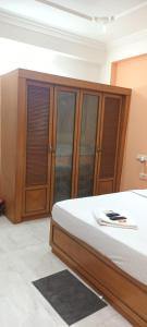 a bedroom with a bed and wooden cabinets at Mithra homes 4 bed rooms independent house in Vidya Nagar