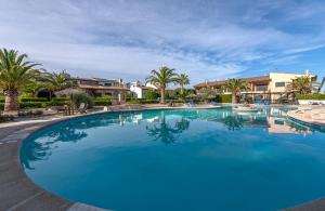 una gran piscina azul con palmeras y casas en Casa Claper, en Campos