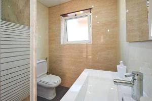 a bathroom with a white toilet and a window at Ericeira Dream Stay in Ericeira