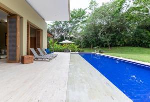 アナポイマにあるClassy 4BR Villa with Pool at Mesa de Yeguasの家の中のスイミングプール(椅子、パラソル付)