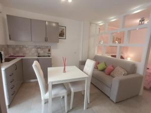 a kitchen and living room with a table and a couch at La casetta di Clary in Polignano a Mare