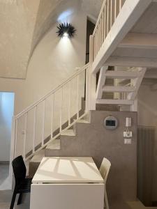 a staircase in a house with a white table and chairs at Casa Manù in Gallipoli