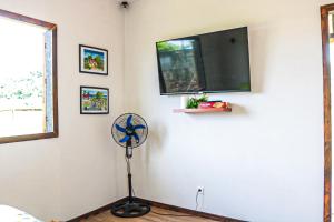 um quarto com uma ventoinha e uma televisão de ecrã plano em Tahaa Cosy Home em Tautu