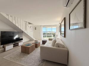 a living room with a couch and a flat screen tv at Magnifique maison avec pisicne in Le Lavandou