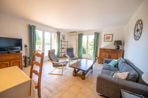 a living room with a couch and a table at Maison pour 6 personnes , climatisée à 500 m de la plage de Saint Clair in Le Lavandou