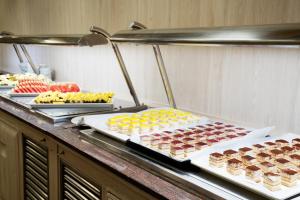 a buffet with many different types of desserts on at Aparthotel Ona Palamós in Palamós