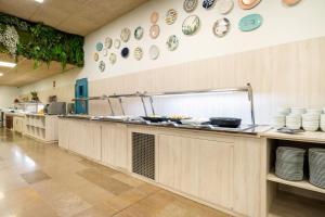 a kitchen with plates and dishes on the wall at Aparthotel Ona Palamós in Palamós