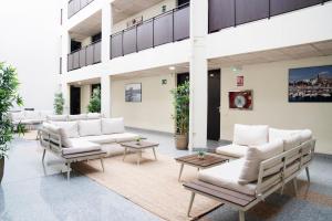 a lobby with couches and tables in a building at Aparthotel Ona Palamós in Palamós