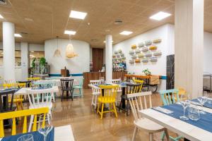 a dining room with tables and chairs in a restaurant at Aparthotel Ona Palamós in Palamós