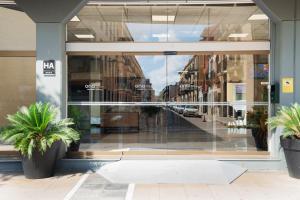 a store front window with a reflection of a street at Aparthotel Ona Palamós in Palamós
