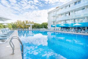 a swimming pool in front of a hotel at Aparthotel Ona Palamós in Palamós