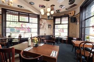 a restaurant with wooden tables and chairs and windows at Town House Rooms in Hastings