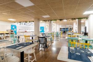 a restaurant with tables and chairs in a room at Aparthotel Ona Palamós in Palamós