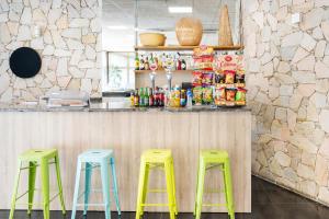 a bar with three green stools in front of a counter at Aparthotel Ona Palamós in Palamós