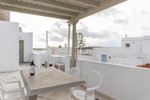a table and chairs on a balcony with a bottle of wine at Azur Playa Naxos in Naxos Chora +47 photos
