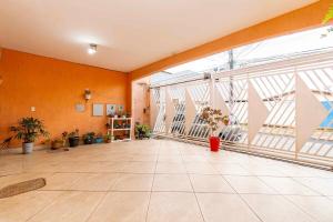 an empty room with orange walls and a large window at Quarto aconchegante no centro de Brasília in Brasilia
