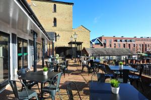 an outdoor patio with tables and chairs and buildings at The White Hart Inn by Greene King Inns in Buckingham