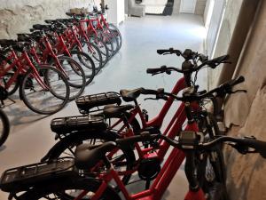 eine Reihe roter Fahrräder, die in einem Raum geparkt sind in der Unterkunft Logis Hotel Le Cerf in Briare