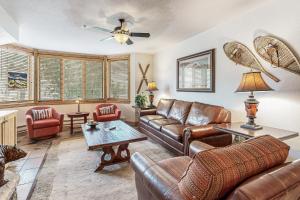 sala de estar con muebles de cuero y ventilador de techo en Torian Plum Creekside 211, en Steamboat Springs