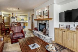 Una sala de estar con chimenea y televisión. en Torian Plum Creekside 211, en Steamboat Springs