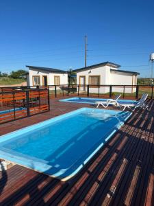 einen Pool auf einer Terrasse mit einem Haus im Hintergrund in der Unterkunft Alojamiento Itati in Colón