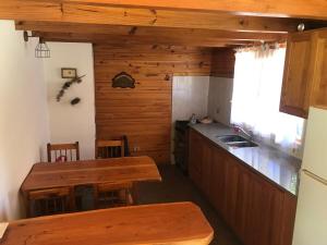 a kitchen with a table and a counter top at Cabaña SOLO 42 - Villa Lago Meliquina in Villa Meliquina +15 photos