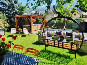 ogród z altaną i krzesłami na dziedzińcu w obiekcie Le Cosy Lodge w mieście Le Bourg d'oisans