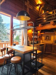 kuchnia ze stołem i krzesłami oraz dużym oknem w obiekcie Le Cosy Lodge w mieście Le Bourg d'oisans