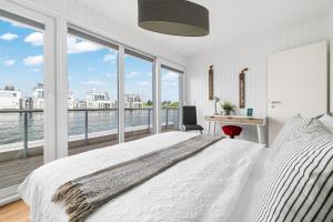 une chambre avec un grand lit et une grande fenêtre dans l'établissement Schleikubus – Ihr schwimmendes Ferienparadies im OstseeResort Olpenitz, à Olpenitz