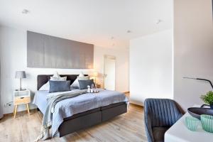 Un dormitorio con una cama grande y una silla. en Shell 65 - On-Suite Apartment ohne Küche in Olpenitz, en Olpenitz 7 fotos más