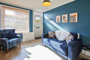 a blue living room with a couch and a window at Host & Stay - Wellington Street in Ripon