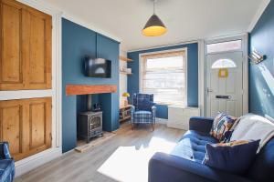 a living room with blue walls and a blue couch at Host & Stay - Wellington Street in Ripon +12 photos