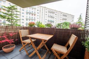 una mesa de madera y 2 sillas en el patio en Apt luxueux 4p avec SAUNA, Proche PARIS, Métro 4, en Bagneux
