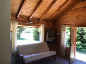 a living room with a couch and a window at Cabaña SOLO 42 - Villa Lago Meliquina in Villa Meliquina