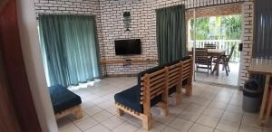 a living room with a bench and a television and a table at 34 Hornbill Street in St Lucia