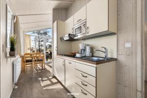 a kitchen with a sink and a microwave at Ferienhaus Spitzenblick 2 - Sankt Andreasberg im Harz in Sankt Andreasberg +17 photos