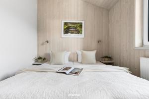 a bedroom with a white bed with a book on it at Ferienhaus Spitzenblick 2 - Sankt Andreasberg im Harz in Sankt Andreasberg