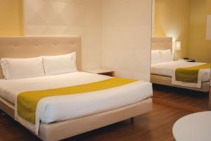 Pokój hotelowy z 2 łóżkami i lustrem w obiekcie Best Western Mirage Hotel Fiera w mieście Paderno Dugnano