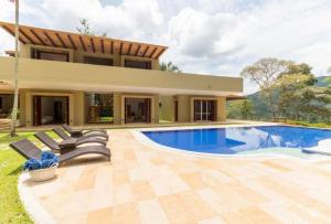 a house with a swimming pool in front of a house at Astonishing 5BR House with pool in Anapoima in Anapoima