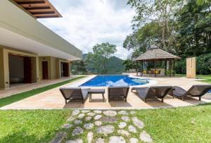 a swimming pool with chairs and a gazebo at Astonishing 5BR House with pool in Anapoima in Anapoima