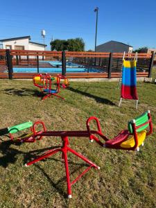 zwei Spielgeräte auf dem Rasen in der Nähe eines Pools in der Unterkunft Alojamiento Itati in Colón