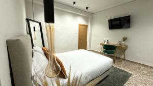 Un dormitorio con una cama, un escritorio y un televisor. en Beach Room Valencia, NETFLIX, 4 mins walk to the beach, en Valencia