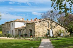 una gran casa de piedra con un patio de césped en Podere Brizio, en Montalcino