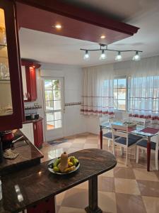 a kitchen and dining room with a plate of fruit on a table at Apartamento Priorato in Isla de Arosa