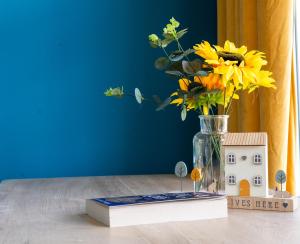 a vase of flowers and a house on a table at Open Mind Property - Hot Tub, 8 Guests & Free Parking in Portsmouth