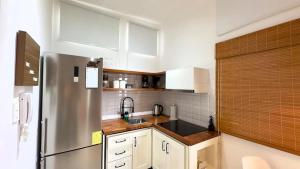 a kitchen with white cabinets and a stainless steel refrigerator at Bungalow entero en Galápagos 77 in Puerto Baquerizo Moreno