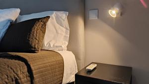 a bedroom with a bed with a remote control on a table at Oasis by Templesuites - Praia da Rocha in Portimão +23 photos