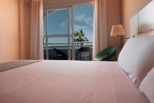 Postel nebo postele na pokoji v ubytování Hotel Vértice Chipiona Mar
