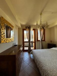 a bedroom with a bed and a dresser and a mirror at Aethera in Revine Lago